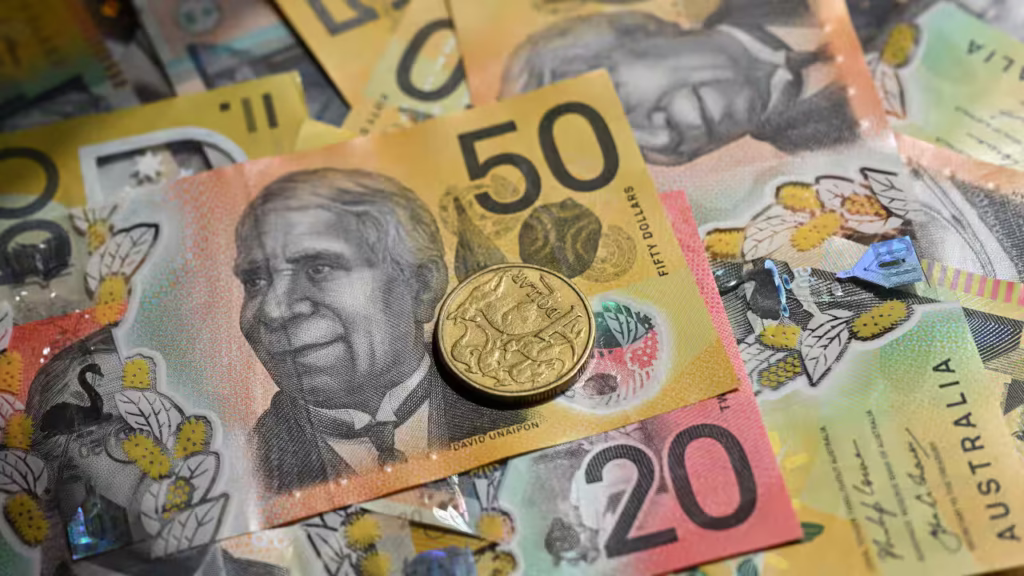 A selection of Australian bank notes and coins laid out in a pile.